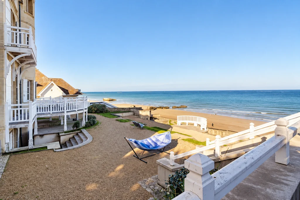 Jardin avec hamac et terrasse devant la plage et la mer
