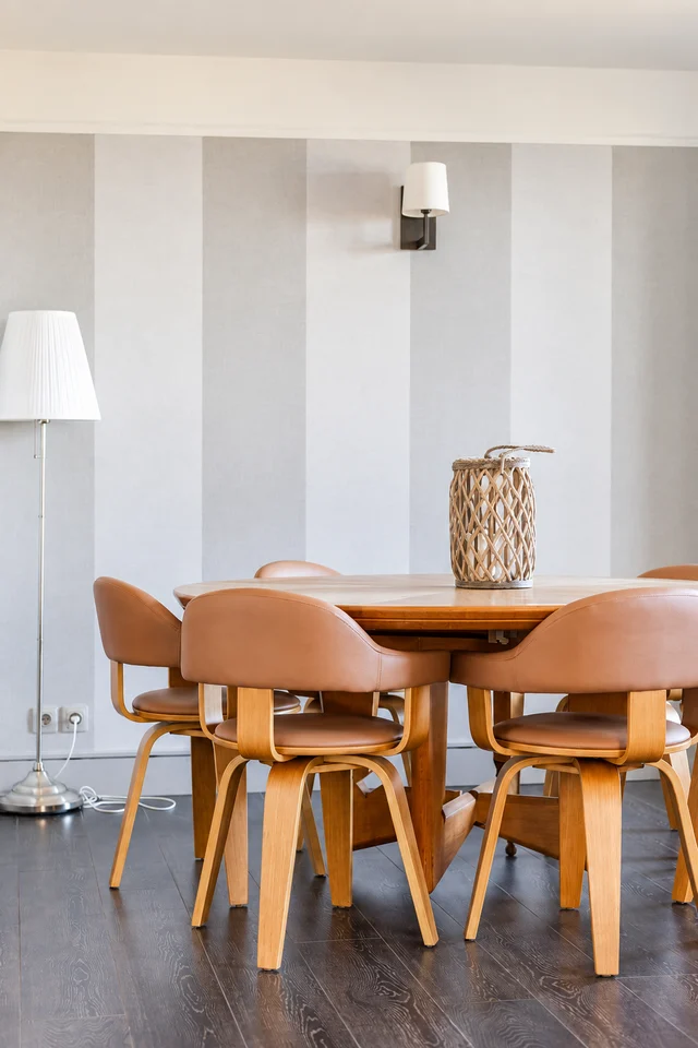 Table ronde en bois, chaises roses et lanterne en rotin