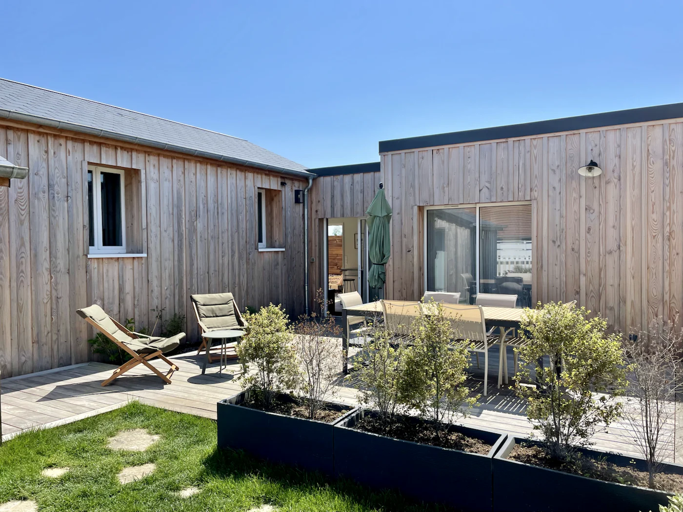 La cour et la façade en bois de La Comète, maison préparée par Bajobreak à Saint-Côme-de-Fresné