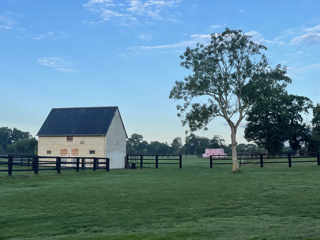 Dépendance en pierre du Logis Courtelay et prairie clôturée à Mosles