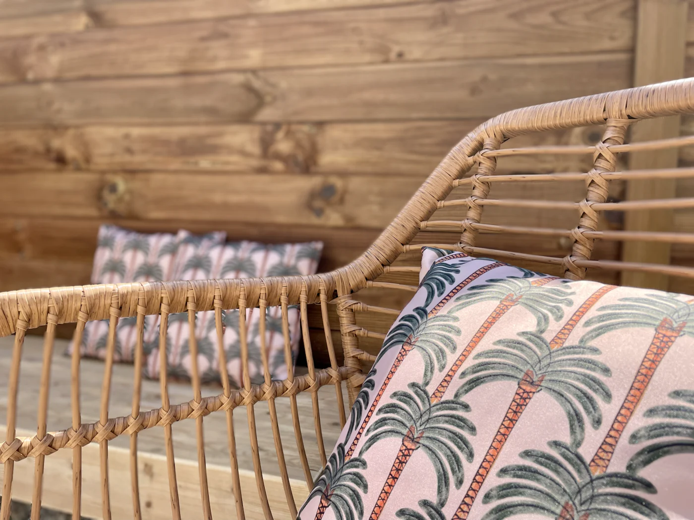 Fauteuil en rotin et coussin aux couleurs végétales dans La Comète