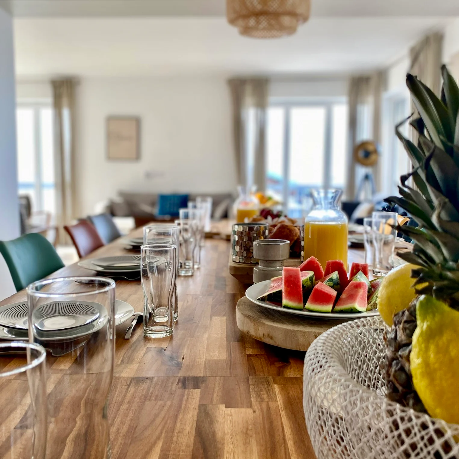 Table dressée avec fruits, pain et petit-déjeuner face à la lumière du littoral