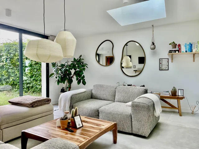 Le salon du logement Terre de La Maison Rose, sa table en bois et ses ouvertures sur le jardin